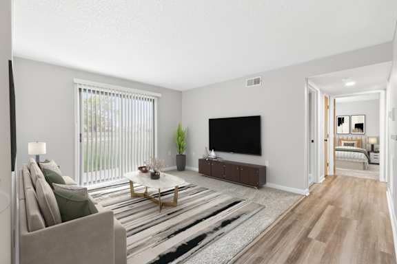 A living room with a couch, a coffee table, and a television.