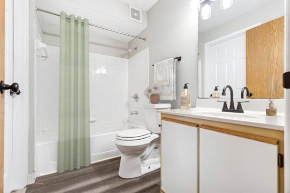 A white toilet sits in a bathroom next to a sink.