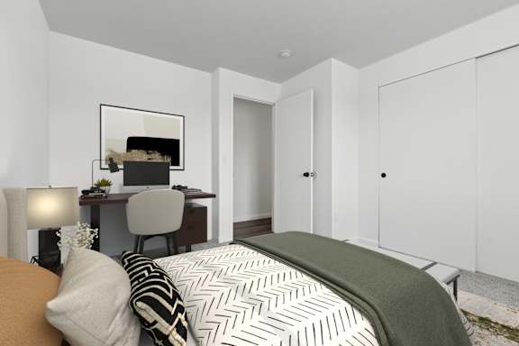 A bedroom with a bed, desk, and chair.