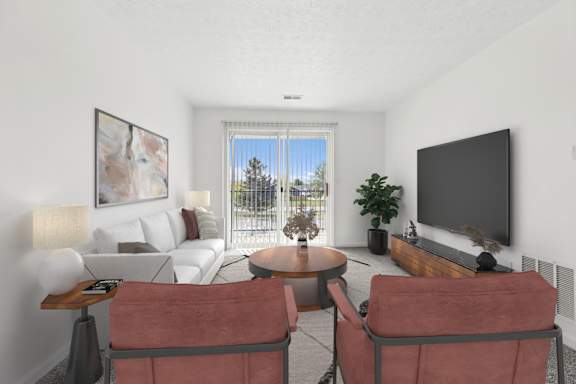 A living room with a white couch, a coffee table, and a flat screen TV.