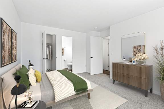 A bedroom with a bed, nightstand, and a plant.
