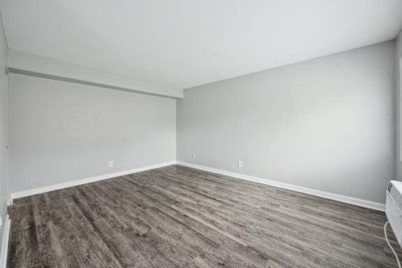 A room with wooden flooring and white walls.