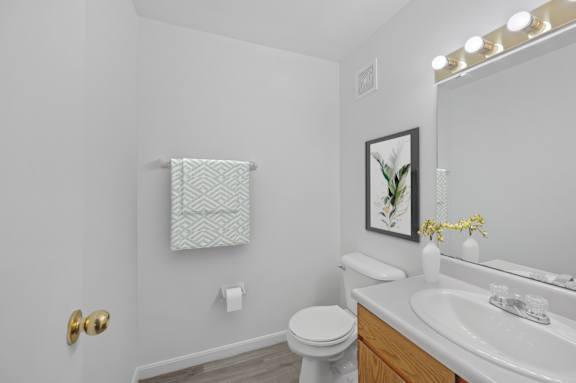 A white toilet sits next to a white sink in a bathroom.