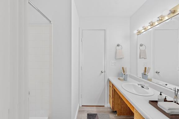 A white bathroom with a sink and mirror.
