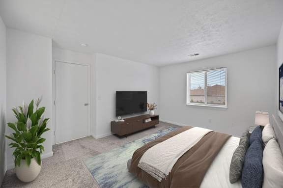 A bedroom with a large bed and a flat screen TV.