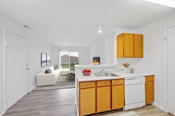 A kitchen with wooden cabinets and a white dishwasher.