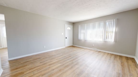 an empty living room with wood floors and a window at Stonebrook of Franklin, Franklin, 46131