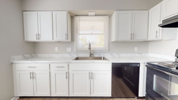 a kitchen with white cabinets and a sink and a window at Stonebrook of Franklin, Franklin, 46131