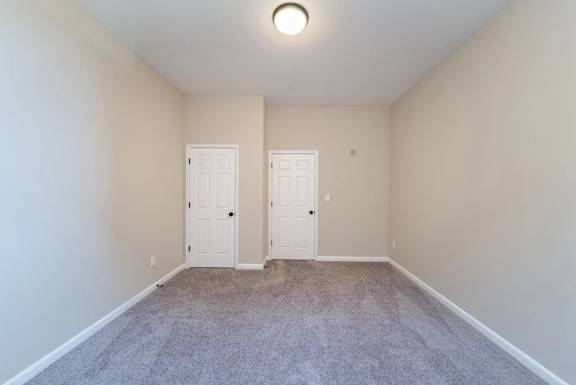 Empty carpeted room with two closet doors at Renaissance at the Power Building Apartments, Ohio, 45202
