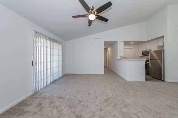 an empty living room with a ceiling fan and a kitchen at Ivy Hills Living Spaces, Ohio