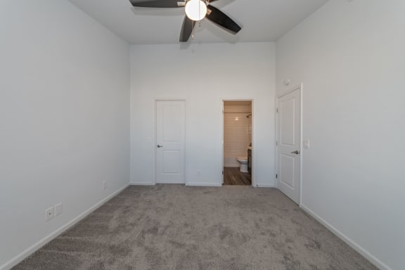 an empty bedroom with a ceiling fan and a door to a bathroom at Ivy Hills Living Spaces, Cincinnati, Ohio