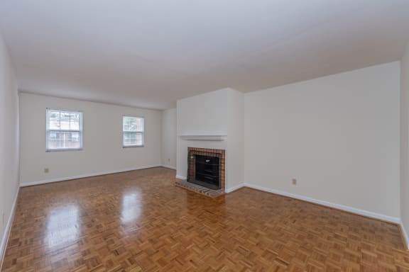 Empty living room with a fireplace and wooden floors at Indian Creek Apartments*, Cincinnati