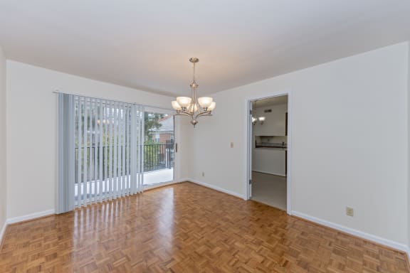 Empty living room with a sliding glass door to a kitchen at Indian Creek Apartments*, Cincinnati, Ohio