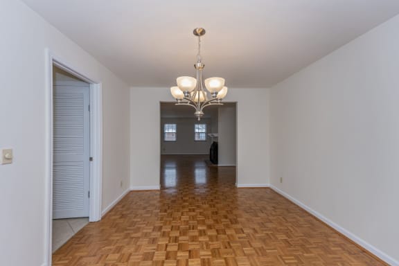 Empty living room with a chandelier and a door to a room with at Indian Creek Apartments, Cincinnati, OH