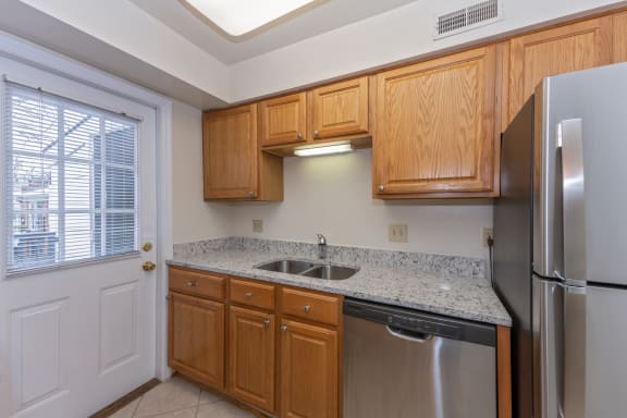 Kitchen with wooden cabinets and stainless steel appliances and granite counter tops at Indian Creek Apartments, Ohio, 45236