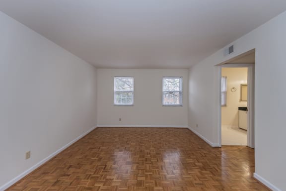 Empty living room with wood flooring and two windows at Indian Creek Apartments*, Ohio, 45236