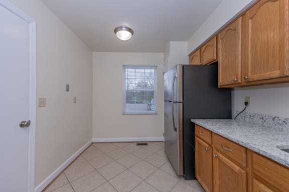 an empty kitchen with a refrigerator and a window at Indian Creek Apartments*, Cincinnati, OH