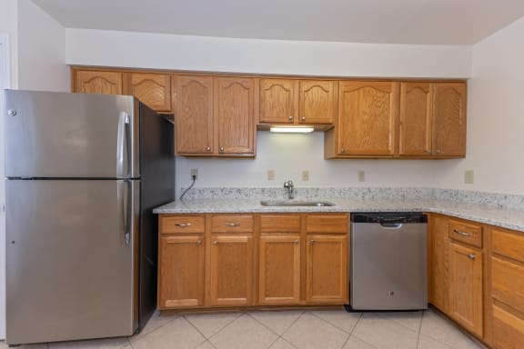 a kitchen with wooden cabinets and a stainless steel refrigerator at Indian Creek Apartments*, Ohio