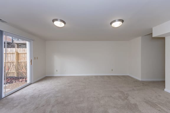 an empty living room with a sliding glass door to a patio at Indian Creek Apartments*, Cincinnati, OH, 45236