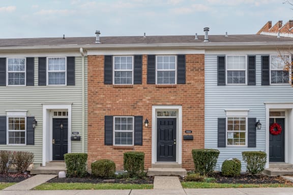 a white house with black doors and a red brick facade at Indian Creek Apartments*, Cincinnati, Ohio