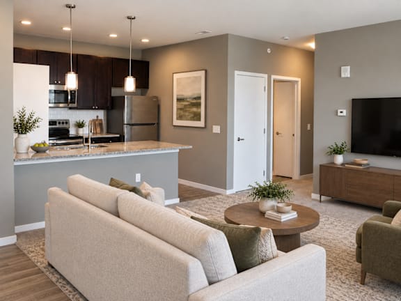 A modern living room with a kitchen area in the background.