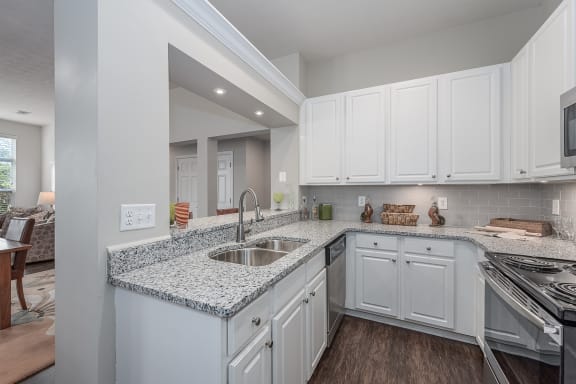 Open kitchen with white cabinets and granite counter tops