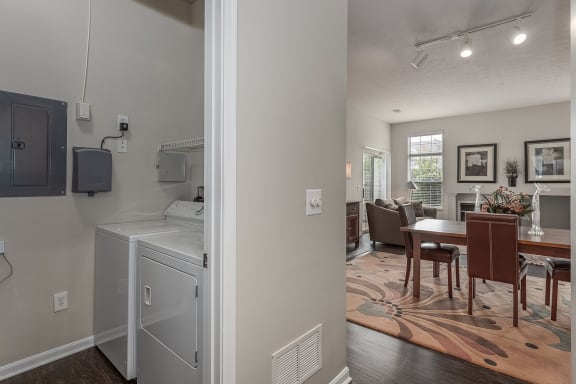 Open kitchen and living room with a dining room table and a washing machine
