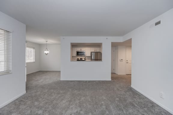 an empty living room with white walls and carpet and a kitchen at Ivy Hills Living Spaces, Cincinnati, 45244