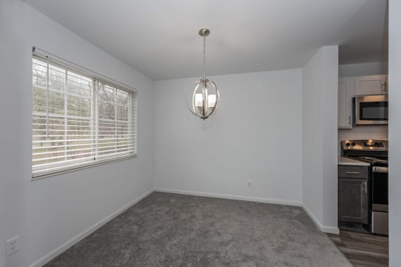 an empty living room with a large window and a kitchen at Ivy Hills Living Spaces, Cincinnati, OH, 45244