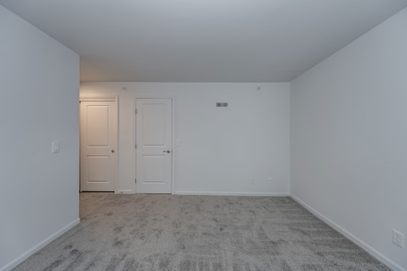 a bedroom with white walls and carpet and two doors at Ivy Hills Living Spaces, Cincinnati, OH