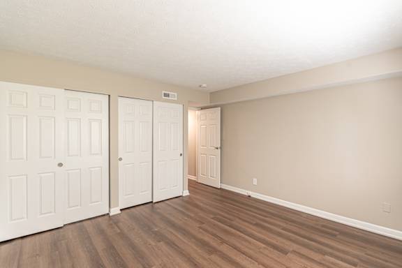 Bedroom with wooden floor and closets at Trails at Mariemont, Ohio, 45227