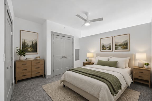 A bedroom with a bed, nightstands, and a ceiling fan.