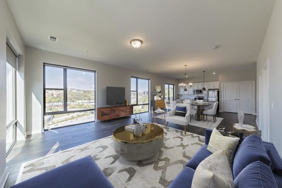 a large living room with blue couches and a table at Adams Edge Apartments, Cincinnati, OH