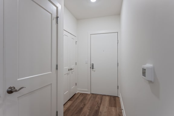 a corridor with white walls and wooden floors and white doors