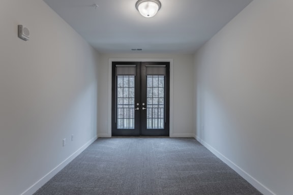 a empty room with white walls and a glass door
