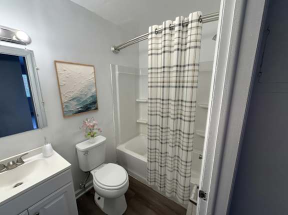 A bathroom with a toilet, sink, and shower.