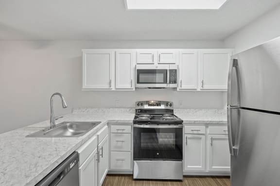 a kitchen with white cabinets and a sink and a refrigerator