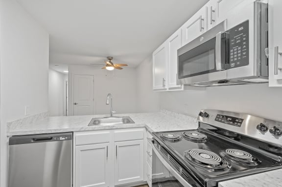 a kitchen with white cabinets and a stove and a microwave