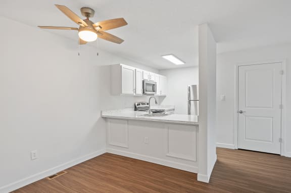 an open living room and kitchen with a ceiling fan