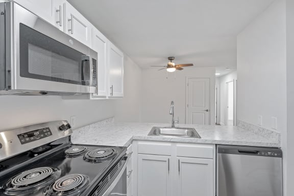 a kitchen with white cabinets and stainless steel appliances and a sink