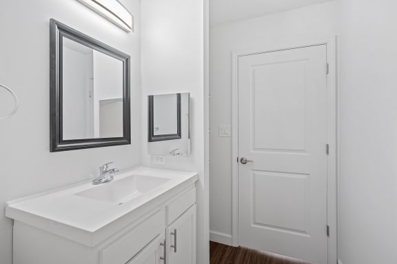 a bathroom with a sink and a mirror and a door