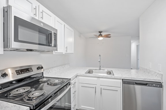 a kitchen with white cabinets and stainless steel appliances and a microwave