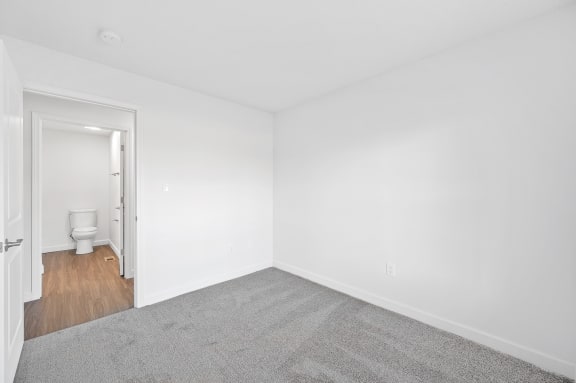 an empty room with white walls and a toilet