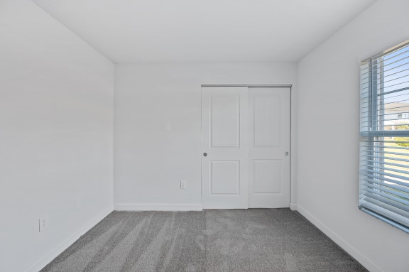 an empty room with white walls and a door and window