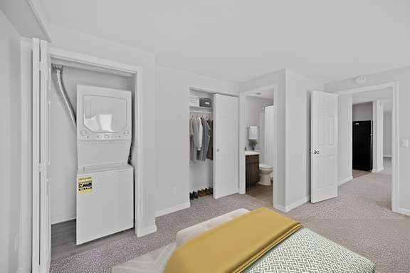 A white room with a bed and a fridge in it.
