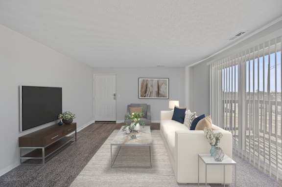 A living room with a white couch, a coffee table, and a television.