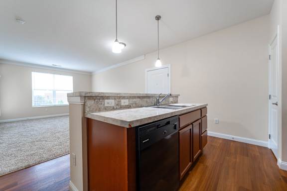 A kitchen with a white counter top and wooden cabinets.