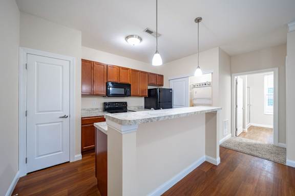 A kitchen with wooden cabinets and a white island.
