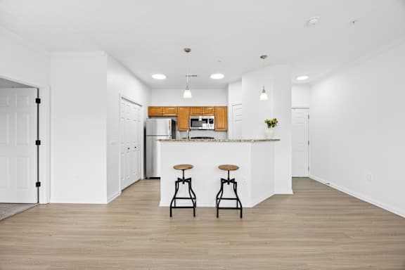 A kitchen with a bar stool in front of it.