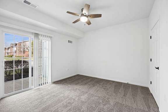 A room with a ceiling fan and a carpeted floor.